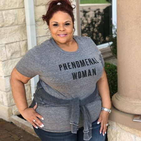 tamela in a grey shirt and pants with her hair up 